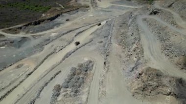 Bir yerden diğerine malzeme yerleştiren çimento ocağı ve kamyonların hava görüntüleri.