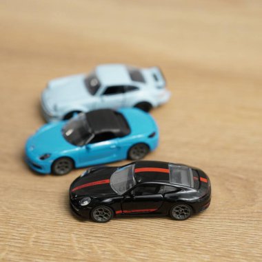 Porsche oyuncak arabalarının yakın çekimi. Tahta bir yüzey üzerinde Majorette marka.