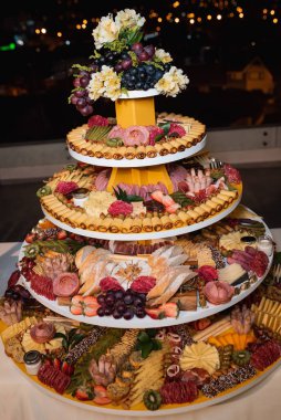 Tütsülenmiş et, peynir ve krakerlerle dolu bir tepsinin üzerindeki şarküteri panosunun dikey seçici odağı