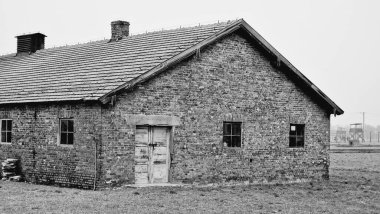 Polonya 'nın Oswiecim kentindeki Auschwitz toplama kampındaki bir binanın gri tonlu görüntüsü