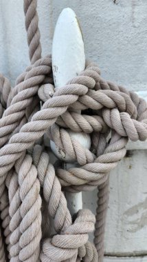 Yelkenlinin direğindeki ipin detaylarının dikey yakın çekimi. Deniz donanımı, deniz düğümü, yolculuk