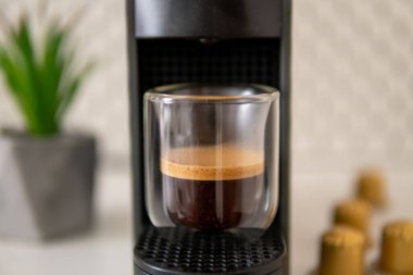 Kahve makinası ve bir bardak kahve.