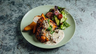 Sosu tavuklu, patatesli ve salatalı bir portre.