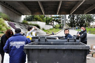 Birkaç gönüllü, Rosario 'daki nehir temizleme günü sırasında Parana nehrinden çıkarılan çöpleri sınıflandırdı.