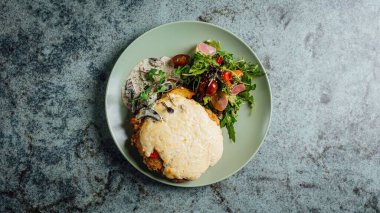 Erimiş peynirli ve sağlıklı salatalı bir et manzarası.