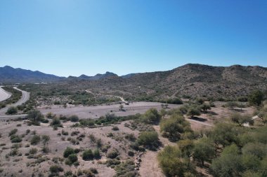Ağaçlı ve dağlı bir manzaranın havadan görüntüsü.