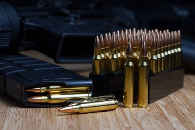 Çeşitli 223 (5.56x45mm) mermiler dolu bir şarjörde AR-15 'in yanında.