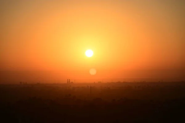 Eine Schöne Aufnahme Eines Leuchtend Orangen Sonnenuntergangs Über Einer Stadt — Stockfoto