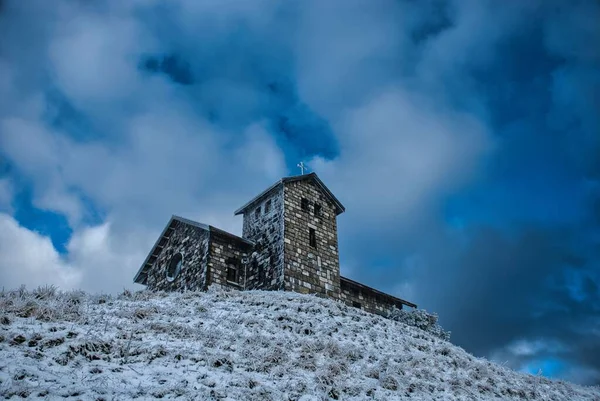 雪に覆われた丘の上にある古い石造りの教会 — ストック写真