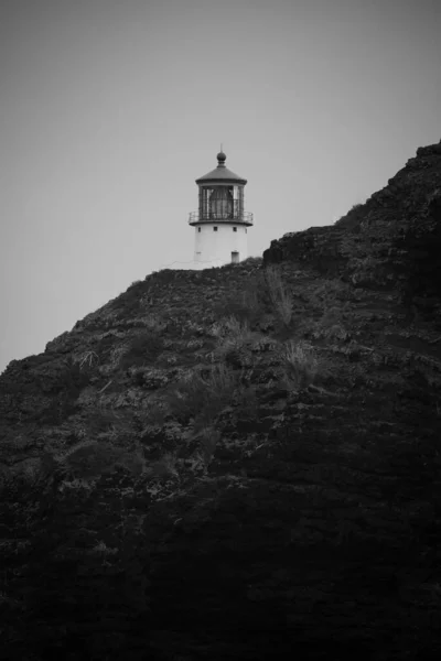 岩の反対側に見える灯台の灰色のショット — ストック写真