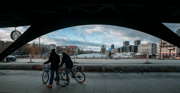 Δύο Άνθρωποι Που Οδηγούν Ποδήλατο Κάτω Από Γέφυρα — Φωτογραφία Αρχείου