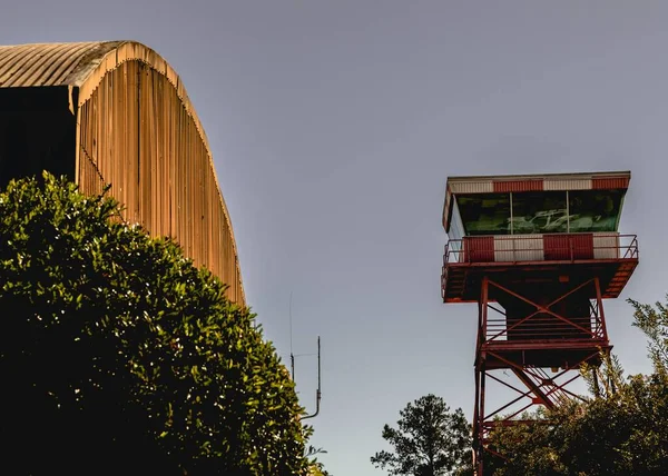 ハンガーと飛行制御塔を持つ時代の飛行基地の低角度晴れ空の背景 — ストック写真