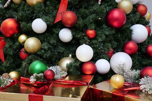 圣诞树上的一个红色 黄色和白色球的特写镜头在附近的礼盒上 — 图库照片