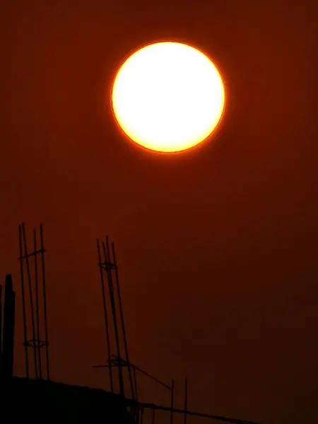 这张照片是在一个建筑工地拍的 在晚上 在这张图中 你可以看到太阳和建筑物并排排列在一起 — 图库照片