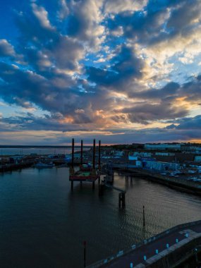 İngiltere 'deki Dartford Köprüsü' nün renkli günbatımı ve şehir binaları manzaralı dikey bir görüntüsü.