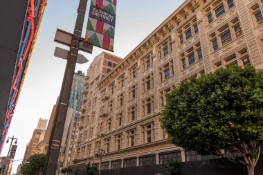 Los Angeles şehir merkezindeki bir binanın alçak açılı görüntüsü ve Moda Bölgesi yazan bir tabela.