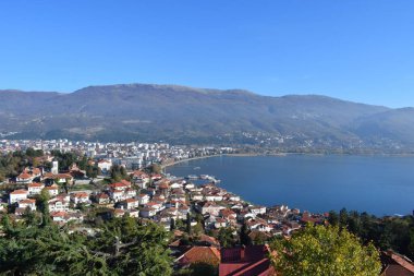 Kuzey Makedonya 'daki su ve dağların yanındaki kırsal evlerle Ohri Gölü' nün hava manzarası