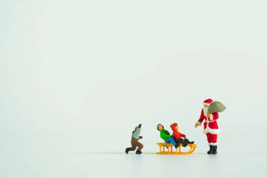 Beyaz arka planda izole edilmiş, Noel temalı minyatür bir figürün yakın plan çekimi.