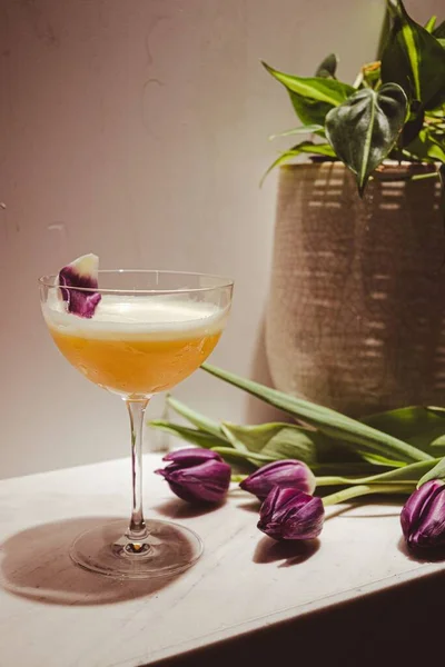Primo Piano Delizioso Cocktail Giallo Accanto Tulipani Viola — Foto Stock