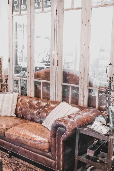 家の装飾で部屋の仕切りとして使用される茶色のヴィンテージのソファとドア — ストック写真