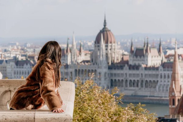 A portrait of a young female on a balcony overlooking Hungarian Parliament, Budapest