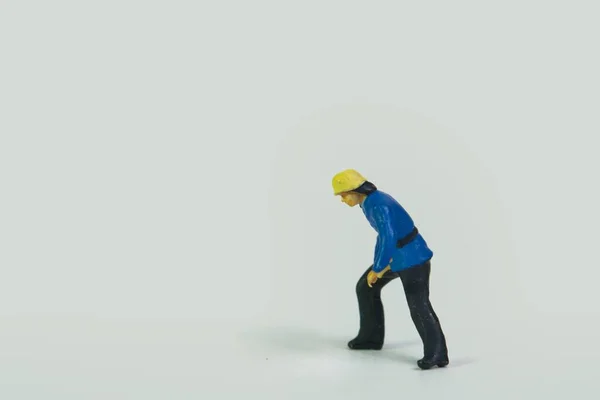 Een Miniatuur Figuur Van Een Brandweerman Staand Een Witte Achtergrond — Stockfoto