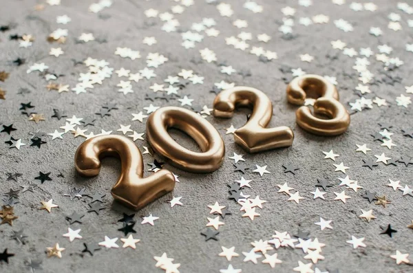 stock image Golden number 2023 on concrete surface sprinkled with confetti