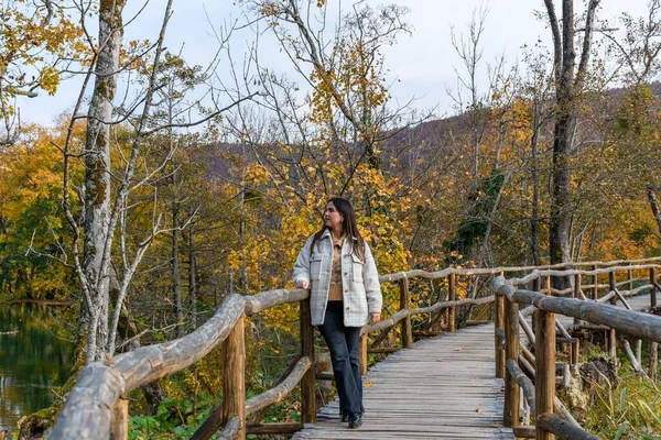 Ung Kvinna Går Träbro Och Beundrar Den Vackra Gula Höstskogen — Stockfoto