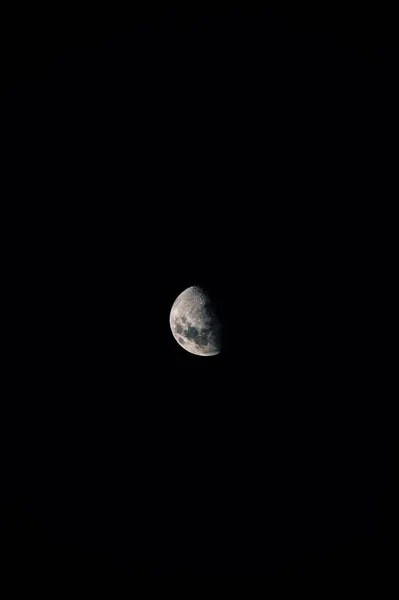 在黑暗的 漆黑的天空中出现的令人毛骨悚然的阶段中的一轮垂直的月亮镜头 — 图库照片