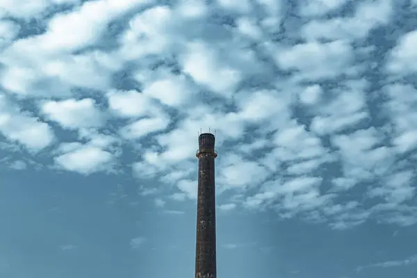 Een Lange Schoorsteen Van Een Fabriek Geïsoleerd Een Blauwe Lucht — Stockfoto