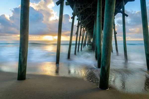 ノースカロライナ州の呉ビーチの桟橋の下で日の出 — ストック写真