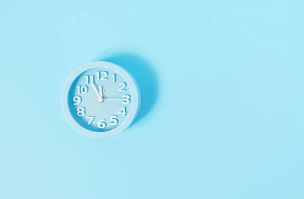 stock image A pastel blue wall alarm clock on blue painted wall-Christmas Eve or New Year concept
