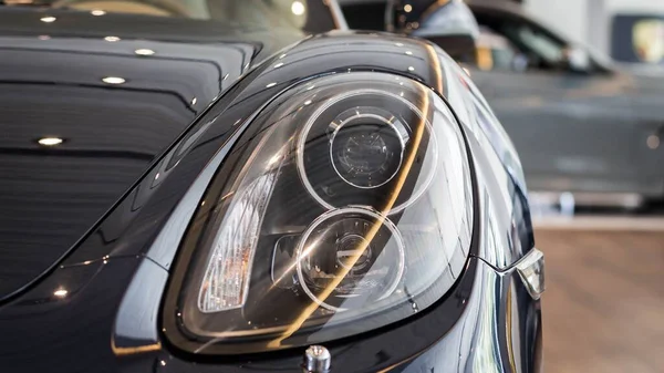 Zbliżenie Przyciętego Światła Głównego Porsche Cayman Zamazane Tło — Zdjęcie stockowe
