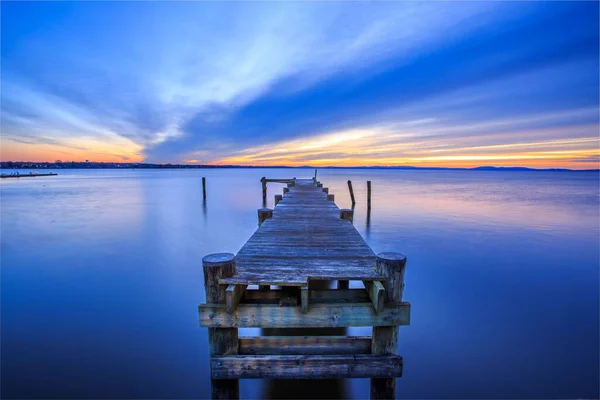 Заброшенный Деревянный Док Завораживающем Море Простирающийся Горизонта Голубым Небом Восходе — стоковое фото