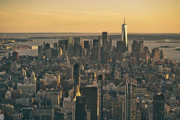 An aerial view of the historic skyline of New York City under a golden sunset sky