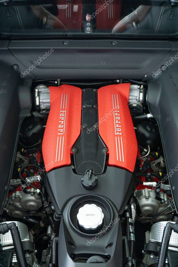 A vertical shot of a Ferrari 488 GTB Engine bay with red engine cover with Ferrari logo