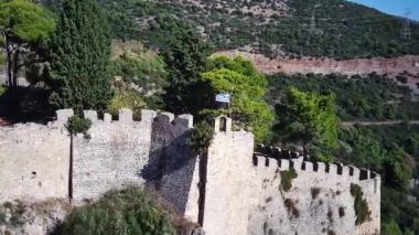Nafpaktos Venedik Kalesi 'nin insansız hava aracı görüntüsü. Rüzgarda dalgalanan Yunan bayrağı.