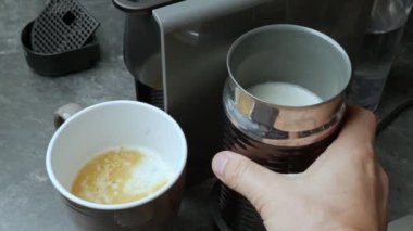 Kahve makinesini kahve yapmak için kullanan birinin yakın çekim görüntüsü.