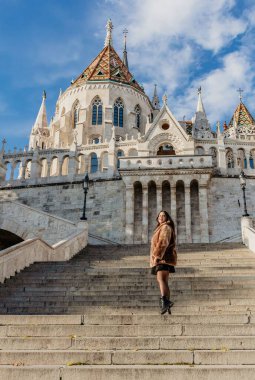 Budapeşte, Macaristan 'daki balıkçı kalesinin önünde dikey çekim yapan genç bir kadın.