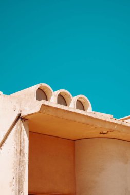 Güneşli bir günde bir binanın tepesinin mavi gökyüzüne karşı dikey görüntüsü.