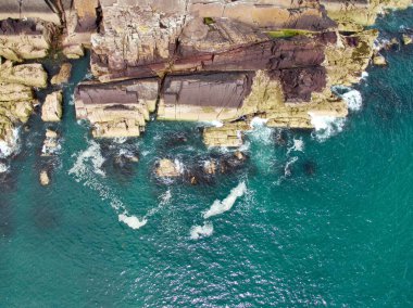 Sabah denize bakan yeşil uçurumların havadan görüntüsü.