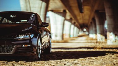 A front view of a black Volkswagen Scirocco under the highway bridge, Prague, Czech Republic clipart