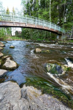 Kayalık nehir boyunca bir yaya köprüsünün dikey görüntüsü.