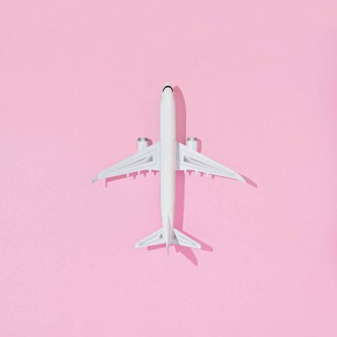 Pembe renkli arka planda izole edilmiş bir uçağın üç boyutlu üst görüntüsü - yaz seyahati konsepti