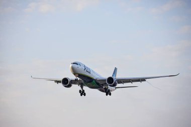 Düşük açılı bir Airbus A330-941 Azul Linhas Aereas uçağı, gün doğumunda uçuyor, arka planda bulutlar var.