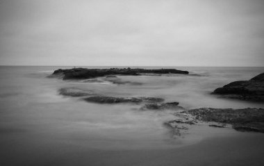 Kaliforniya 'daki Dana Point' in kuzeyindeki Cave Beach 'teki kayaların fotoğrafı. Derinlik hissini yansıtmak için düzenlenmiş, özellikle de zaman içinde..
