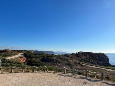 Açık bir yüzey, denizin kayalık kıyı şeridinde ahşap çitlerle kaplı. Açık bir gökyüzü.