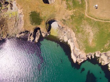 Sabah denize bakan yeşil uçurumların havadan görüntüsü.