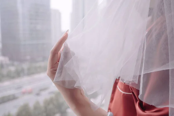窓に立っている女性の白いブライダルベール — ストック写真