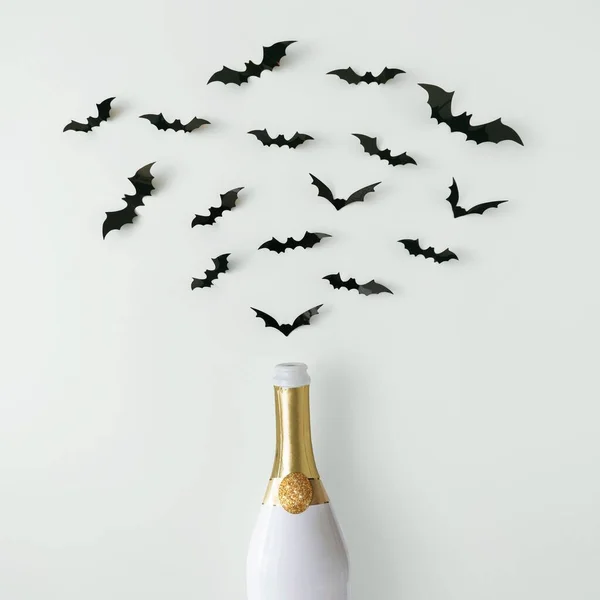 白い壁にバットシルエットの白と金のシャンパンボトル ハロウィンパーティーのコンセプト — ストック写真